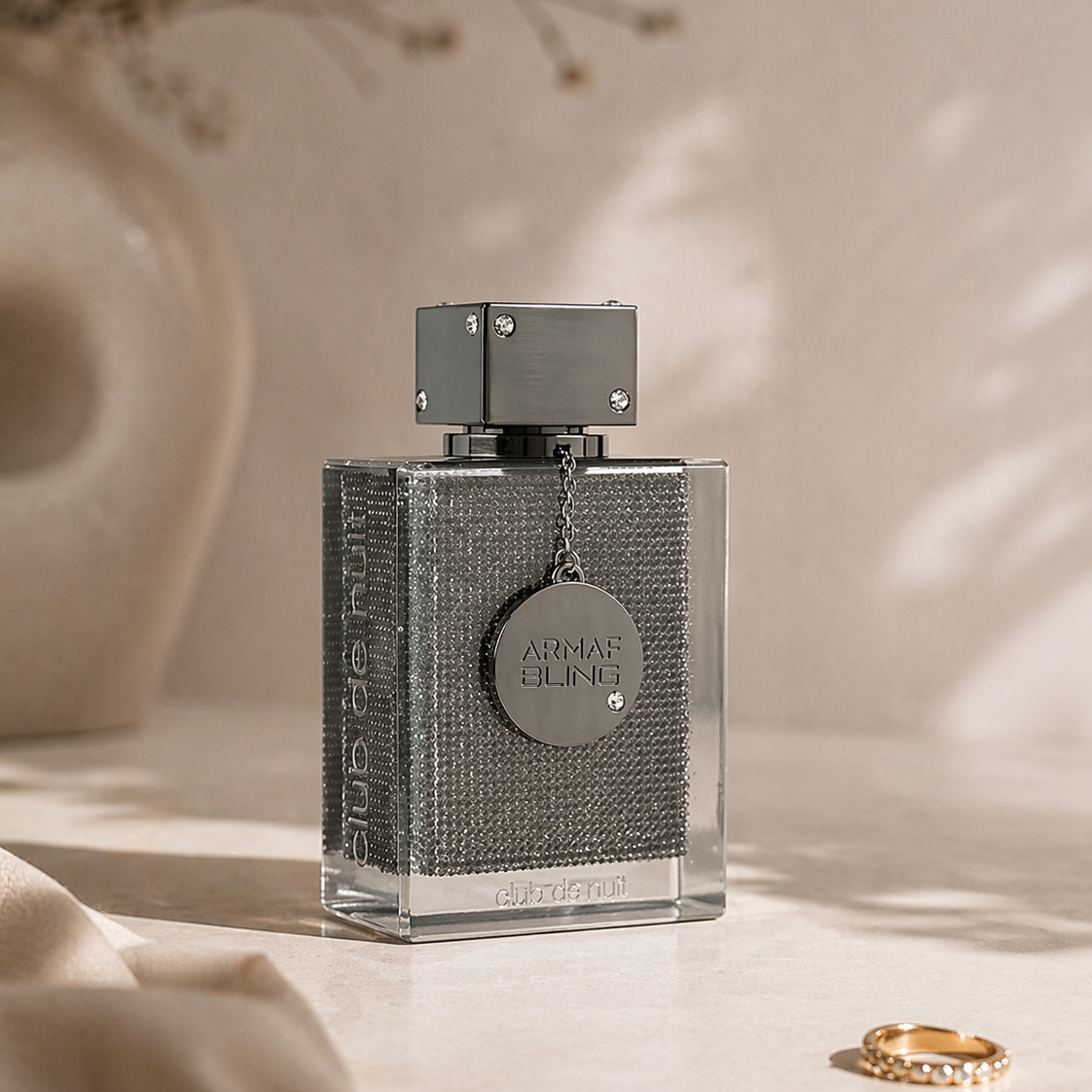 Silver perfume bottle with a textured finish on a neutral background