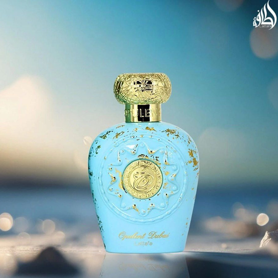 Blue perfume bottle with gold accents on a blurred beach background