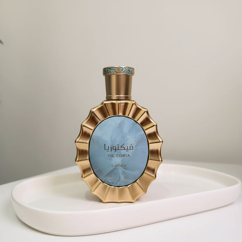 Gold perfume bottle with decorative packaging on a light surface