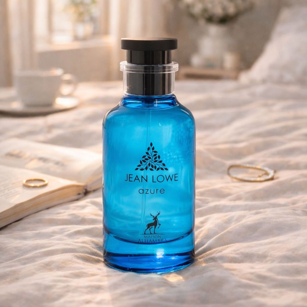 Blue bottle of Jean Lowe perfume on a bed with soft lighting