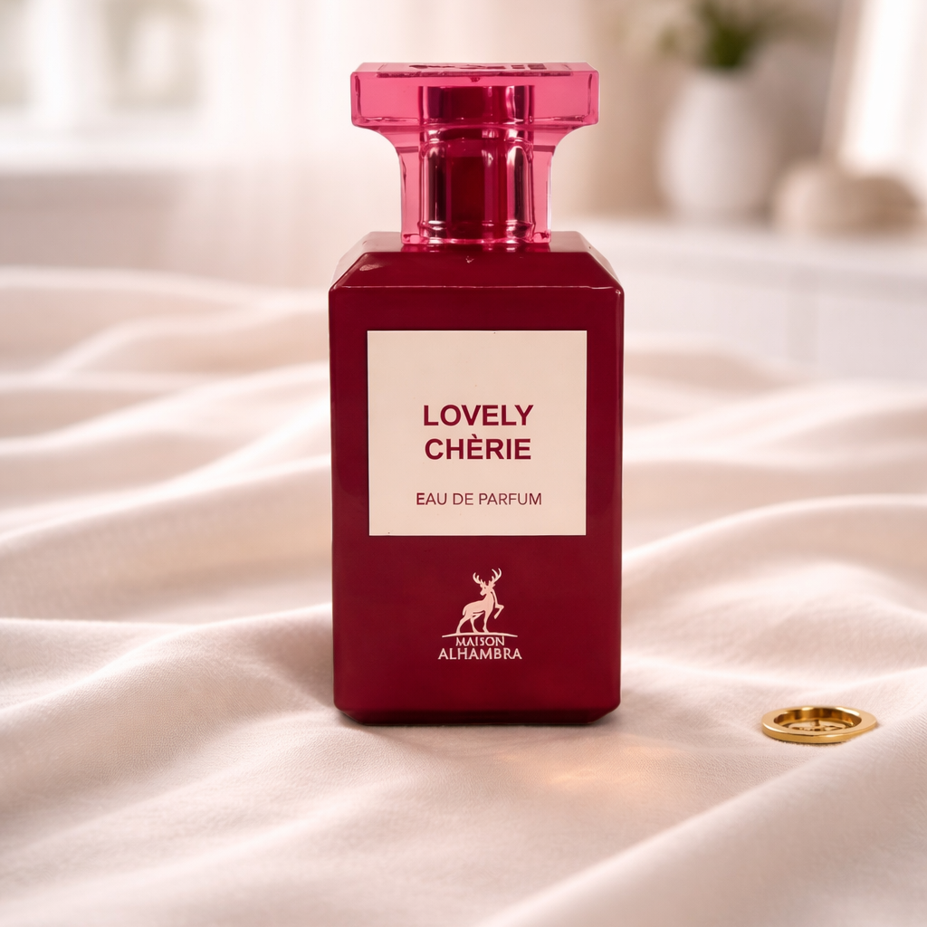 Red 'Lovely Chérie' perfume bottle on a white surface with a blurred background