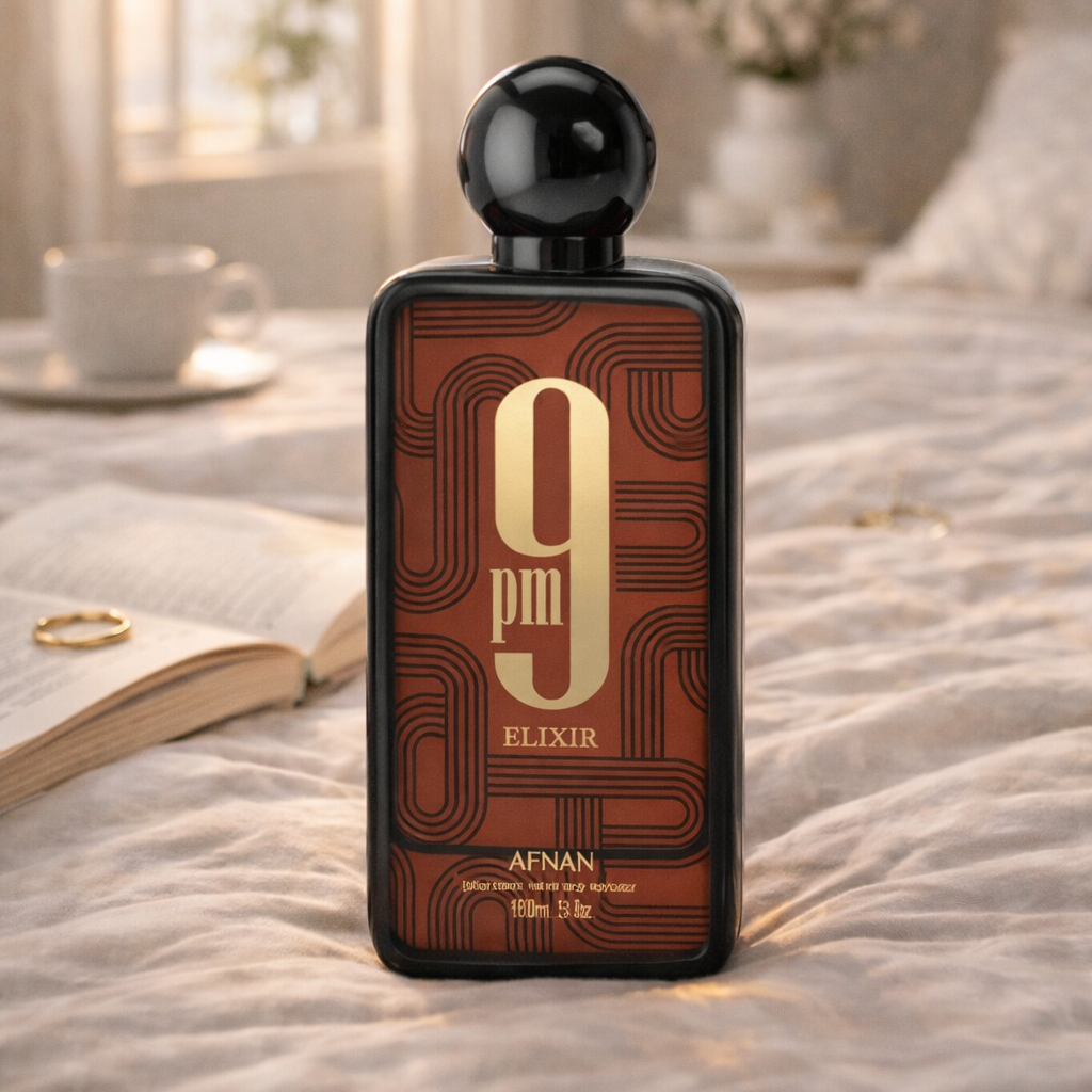 Perfume bottle labeled '9 Elixir' by Afnan on a bed with a soft focus background