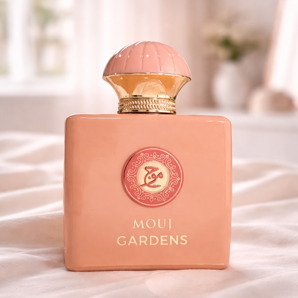 Perfume bottle labeled 'MOUI GARDENS' on a soft, light-colored surface with a blurred background.